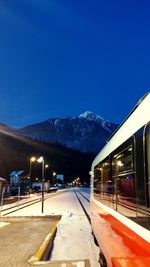 Train on snow covered mountain against clear blue sky