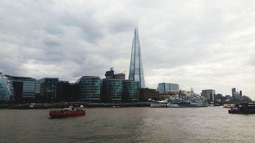 Nautical vessel on sea by buildings against sky in city