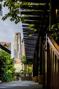 Footpath amidst buildings in city against sky