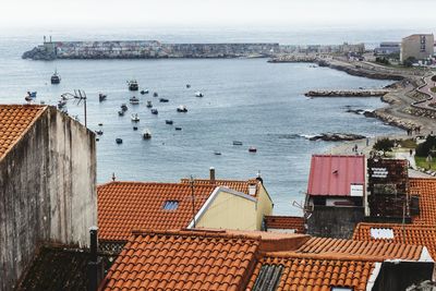 High angle view of city by sea against sky