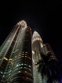 Low angle view of illuminated buildings against sky at night