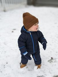Boy standing on snow covered field