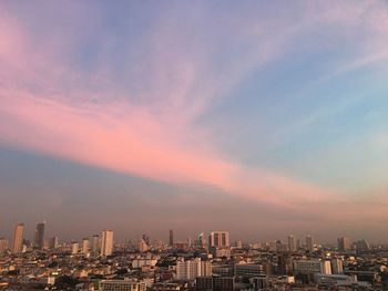 Modern buildings against sky during sunset