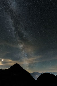 Scenic view of silhouette mountains against sky at night