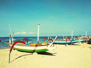 Deck chairs on beach against clear blue sky