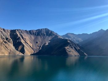 Scenic view of lake and mountains against blue sky