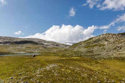 Scenic view of land and mountains against sky