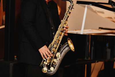 Midsection of man playing piano