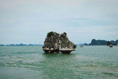 Scenic view of rocks in sea against sky