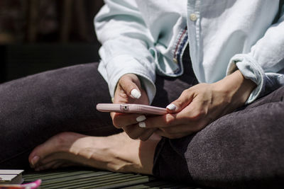 Midsection of man using mobile phone