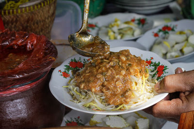 Close-up of hand holding food served on table