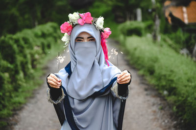 Portrait of woman standing against plants