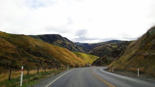 Empty road along countryside landscape