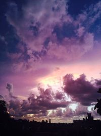 Silhouette of trees against cloudy sky