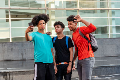 Multiethnic friends taking selfie in the street