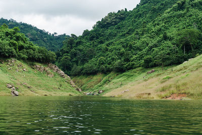 Scenic view of lake by mountains against sky