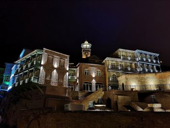 Low angle view of illuminated buildings against sky at night