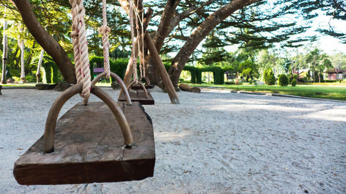 Empty park bench by footpath in city