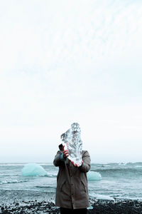 Man standing on beach against sky