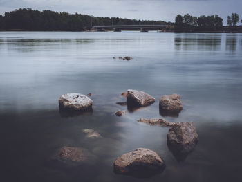 Rocks in lake against sky