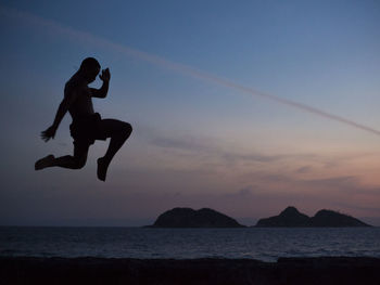Muay-thai fighter on the beach in backlight during sunset