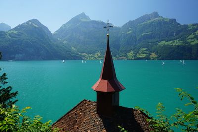 Scenic view of lake by mountains against sky