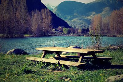 Bench on shore against mountains