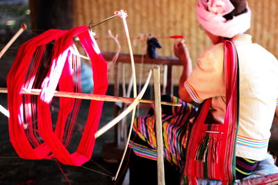 Rear view of man working on loom