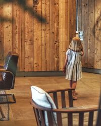 Rear view of boy standing on table