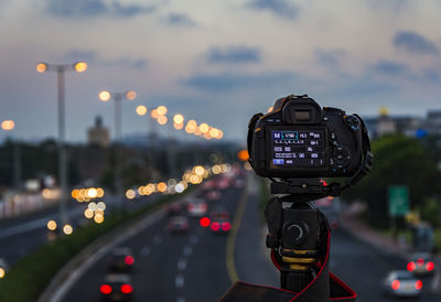 Camera against road in city during sunset