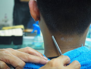 Cropped hands of barber cutting customer hair in salon