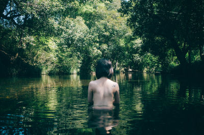 Shirtless woman swimming in lake