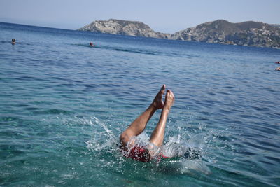 Low section of man swimming in sea