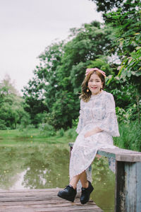 Portrait of woman sitting against lake