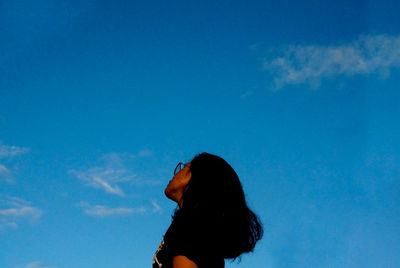 Young woman against blue sky