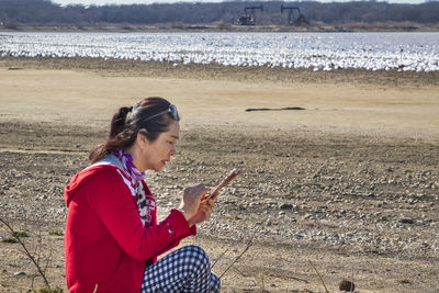 Woman using mobile phone at beach