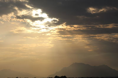 Low angle view of silhouette mountain against dramatic sky