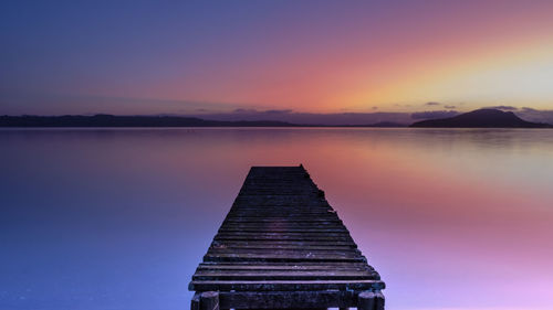 Scenic view of lake against sky at sunset