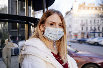 Beautiful girl in a medical mask. protection from coronavirus on the street in pandemic.