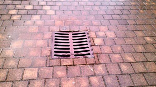 High angle view of manhole on cobblestone street