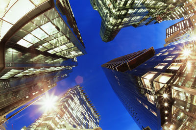 Low angle view of illuminated buildings against blue sky