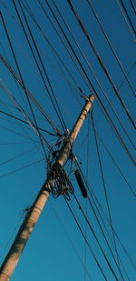 Low angle view of cables against clear blue sky