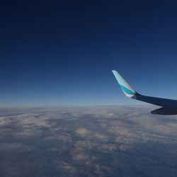 Airplane wing against blue sky