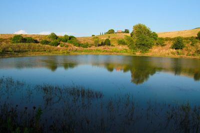 Scenic view of lake against clear blue sky