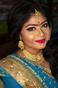 An indian teenage girl happy with indian ethnic wear and ornaments in a marriage reception party