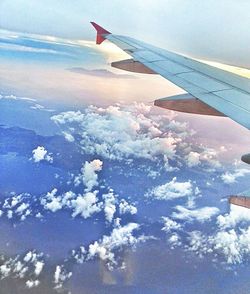 Cropped image of airplane flying over clouds