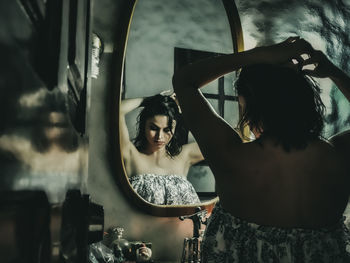 Reflection of woman standing on mirror