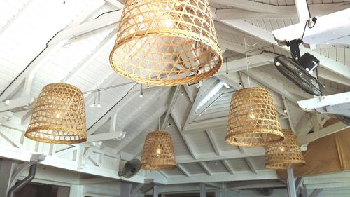 Low angle view of illuminated lighting equipment hanging on ceiling