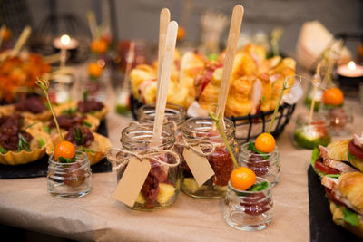 Catering in jars with wooden forks. cold snacks, croissant sandwiches, tartlets, canapés in jars