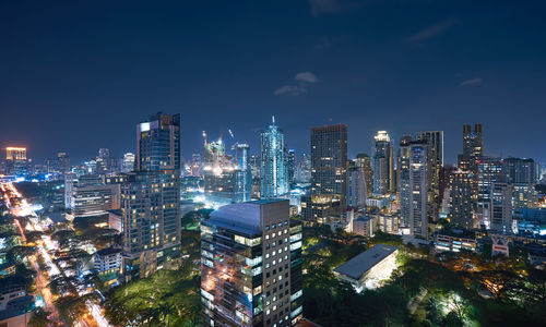 Illuminated buildings in city against sky at night